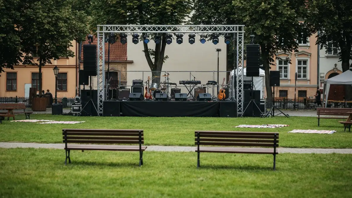 Letnia scena koncertowa w centrum Białegostoku z zielenią i zabytkowymi kamienicami w tle