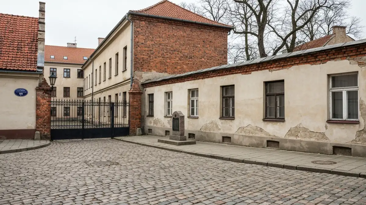 Pusta brukowana ulica w centrum Bialegostoku z kamieniem pamieci i przedwojennymi kamienicami